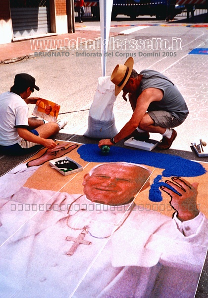 BRUGNATO (Infiorata del Corpus Domini 2005) - In Via Briniati due infioratori danno vita ad un ritratto di Papa Giovanni Paolo II che saluta i fedeli e sorride