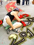 BRUGNATO (Infiorata del Corpus Domini 2010) - Un infioratore compone il logo e la data della manifestazione sul piazzale antistante la chiesa