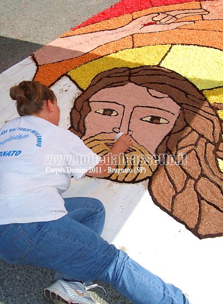 BRUGNATO (Infiorata del Corpus Domini 2011) - Un'infioratrice sta ultimando il volto del Cristo