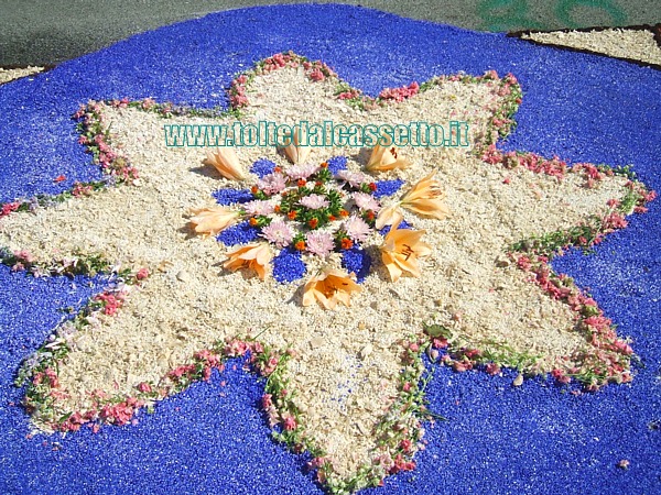 BRUGNATO (Infiorata del Corpus Domini 2011) - Disegno a forma di stella composto da fiori interi, petali sminuzzati e sabbia colorata