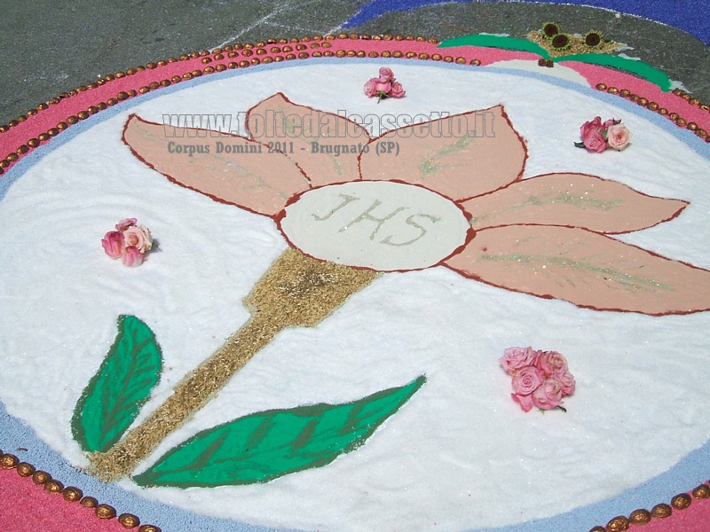 BRUGNATO (SP) - INFIORATA DEL CORPUS DOMINI 2011 - Disegno di un petalo di fiore contornato da rose, realizzato principalmente con sale e sabbia colorata