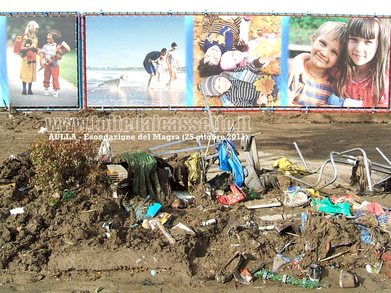 AULLA - Le scene di una serena vita familiare presenti in alcuni poster stradali contrastano con i detriti e il fango portati dall'alluvione