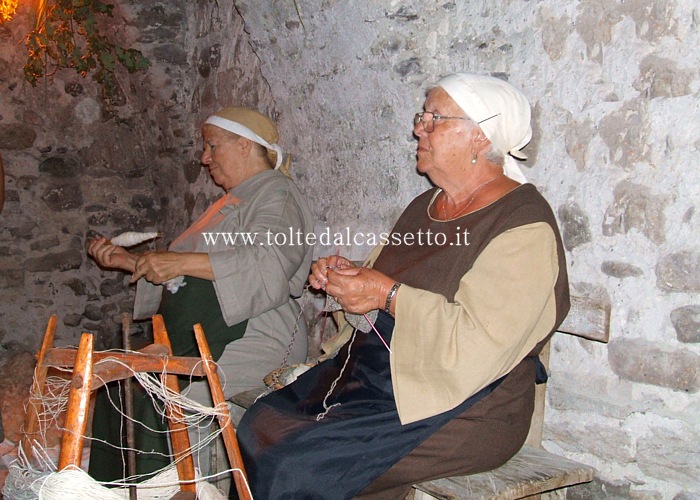 S.STEFANO MAGRA - Due figuranti in costume storico intente a filare e lavorare a mano la lana durante la "Rievocazione di un antico mercato sulla Via Francigena"
