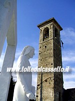 VILLAFRANCA LUNIGIANA - Il monumento a Dante Alighieri si staglia a fianco del campanile della chiesa di San Nicol, antico ospitale per i pellegrini lungo la Via Francigena