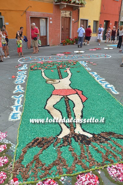 BRUGNATO (Infiorata del Corpus Domini 2015) - In Piazza San Pietro un quadro raffigurante il Cristo in croce. Ai lati la scritta "Io sono la vite, voi i tralci"