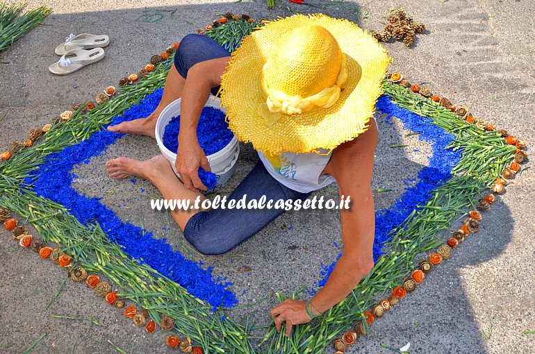 BRUGNATO (Infiorata del Corpus Domini 2015) - Un'infioratrice compone un disegno a forma di rombo utilizzando gambi di garofano e roselline rosse