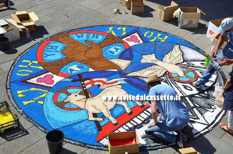 BRUGNATO (Infiorata del Corpus Domini 2017) - Allestimento quadro rappresentante la Santissima Trinit� con le tre figure simboliche (mano = Padreterno; agnello = Cristo; colomba = Spirito Santo) del Dio "uno e trino"