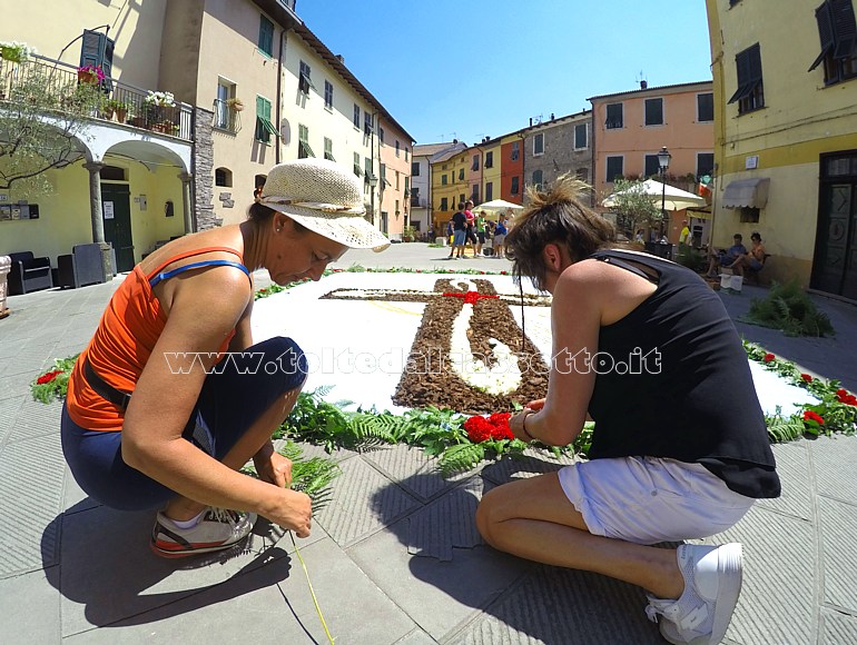 BRUGNATO (Infiorata del Corpus Domini 2022) - In Piazza Brosini due infioratrici contornano un quadro con disegno di una croce