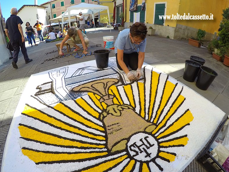BRUGNATO (Infiorata del Corpus Domini 2025) - Infioratrici al lavoro sul logo di Via Riva d'Armi