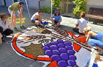 BRUGNATO (Infiorata del Corpus Domini 2026) - Quadro con figure di grappolo d'uva e spighe di grano in Via Riva D'Armi