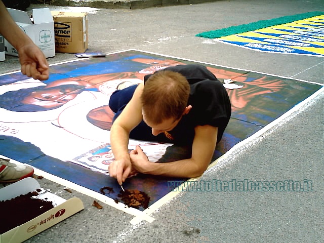 BRUGNATO (Infiorata del Corpus Domini 2006) - Un infioratore utilizza fondi di caff per decorare un quadro raffigurante la Sacra Famiglia