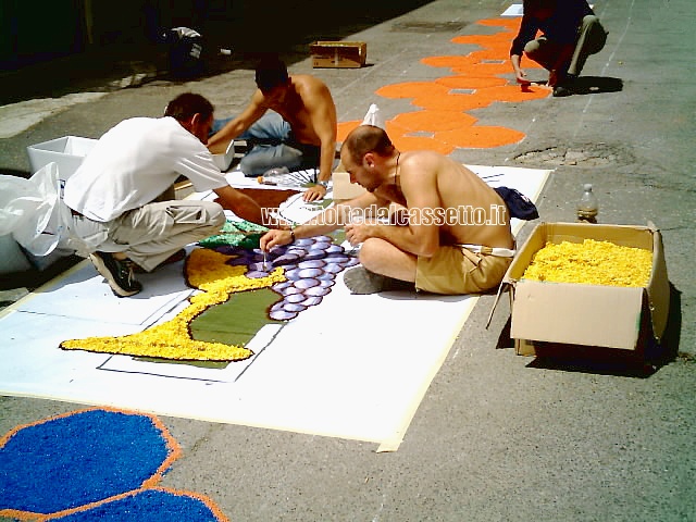 BRUGNATO (Infiorata del Corpus Domini 2006) - Infioratori danno vita al disegno di un calice con grappolo d'uva