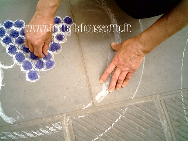 BRUGNATO (Infiorata del Corpus Domini 2006) - Mani esperte abbozzano un grappolo d'uva