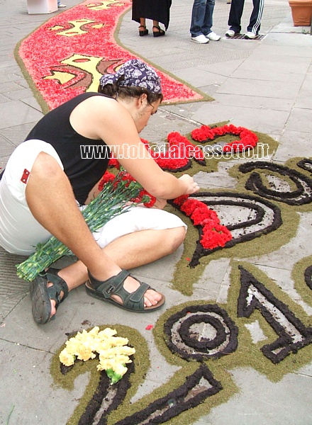 BRUGNATO (Infiorata del "Corpus Domini 2010") - Un infioratore compone il logo e la data della manifestazione sul piazzale antistante la chiesa
