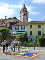 BRUGNATO (Infiorata del Corpus Domini 2013) - Un gruppo di visitatori osserva un quadro floreale in Via Briniati. Sullo sfondo il campanile della chiesa
