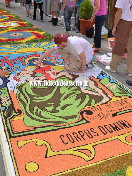 BRUGNATO (Infiorata del Corpus Domini 2014) - Nel Borgo San Bernardo ultimi ritocchi per il quadro raffigurante la Madonna e recante le scritta "Pace in terra, amore nei cuori"