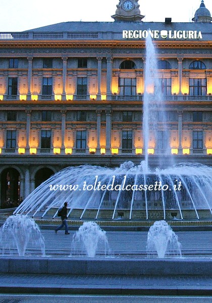 GENOVA - Al calar della sera la fontana di De Ferrari si staglia sul palazzo sede della Regione Liguria illuminato