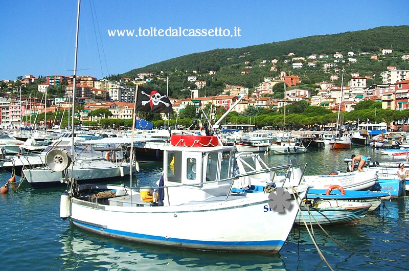 LERICI - Imbarcazioni all'ormeggio nel porticciolo dove su un natante da pesca è issata la bandiera col teschio simbolo della pirateria