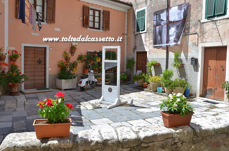 TORANO (Notte e Giorno 2016) - Piazzetta caratteristica con scultura in marmo bianco di Massimiliano Roncatti raffigurante una testa tagliata da una ghigliottina