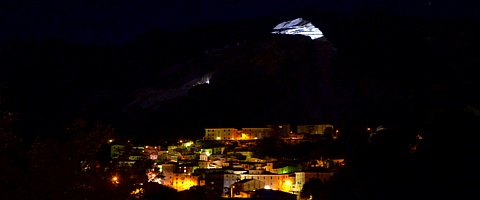 TORANO - Panorama notturno durante la rassegna d'arte "Notte e Giorno" quando le montagne retrostanti sono illuminate da potenti fari