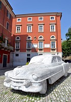 CARRARA - Il Palazzo Rosso fa da sfondo ad una Cadillac in marmo a grandezza naturale CARRARA - Il Palazzo Rosso fa da sfondo ad una Cadillac in marmo a grandezza naturale