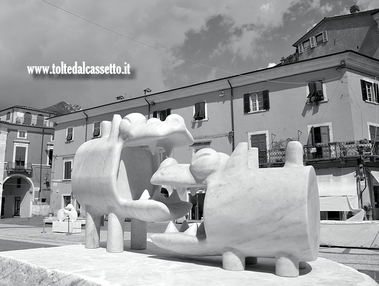 WHITE CARRARA 2025 (Design Here And Now) - Scultura in marmo bianco "Cane mangia Cane" di Massimo Giacon esposta in Piazza Alberica