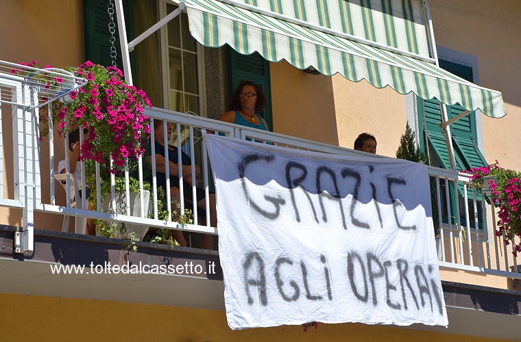 SERRICCIOLO di AULLA - Un drappo appeso al balcone di un'abitazione porta i ringraziamenti della popolazione per gli operai della ditta Edilturci che hanno costruito il nuovo ponte stradale sull'Aulella a tempo di record