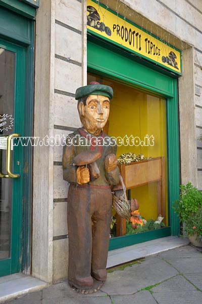 PONTREMOLI - "Fungaiolo", scultura in legno del maestro d'ascia Gino Fogola in esposizione presso un esercizio commerciale di prodotti tipici