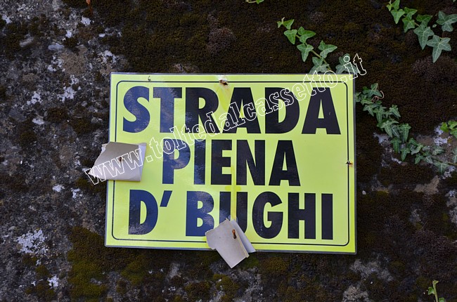CARTELLI CURIOSI E DIVERTENTI - "Strada piena d' bughi" recita in dialetto questo avviso che ci avverte che la strada � piena di buche. Anche questo � un modo per tenere viva la lingua del posto...