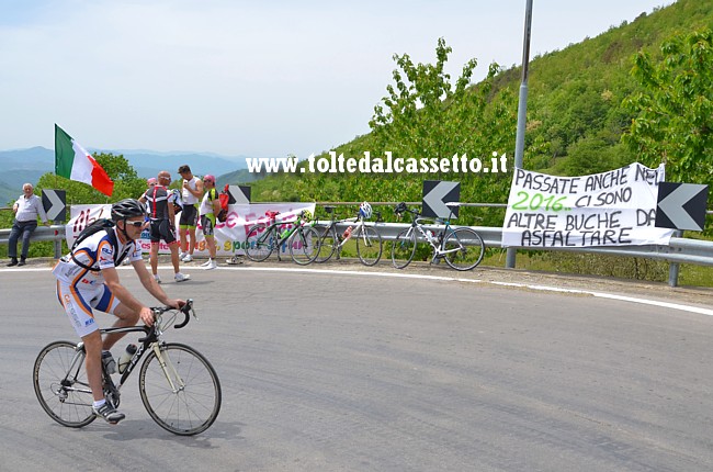 CARTELLI CURIOSI E DIVERTENTI - "Passate anche nel 2016, ci sono altre buche da asfaltare" recita uno striscione affisso lungo la strada del Passo dei Carpinelli durante il transito del Giro d'Italia 2015