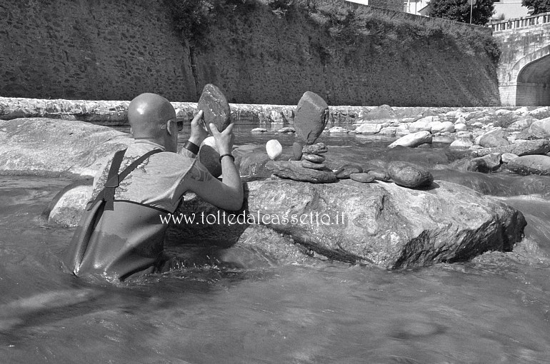 CIBART 2017 (Seravezza) - Immerso nell'acqua del torrente Vezza l'artista Nicola Daniele Fortuna compone una delle sue sculture che originano da pietre poste in equilibrio l'una sull'altra