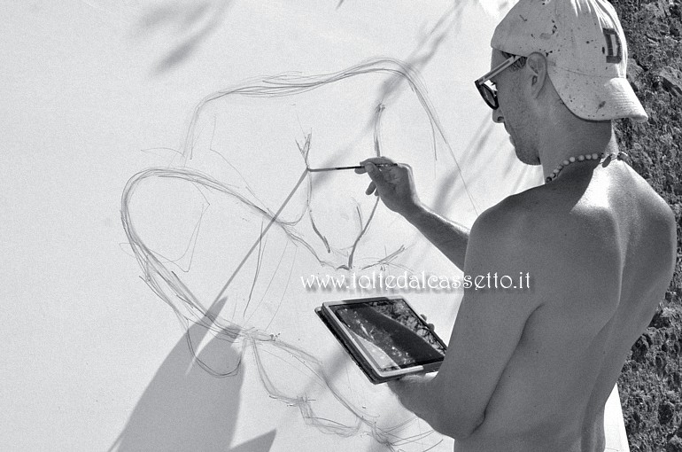 CIBART 2017 (Seravezza) - Il painter Daniele Castagnetti inizia il suo lavoro nel greto del torrente Vezza aiutandosi con un moderno tablet per visionare il disegno da riprodurre
