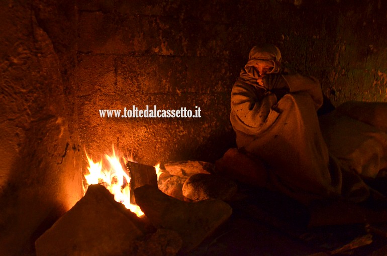MASSA (Presepe vivente interattivo) - Mendicante si riscalda vicino ad un fuoco da campo