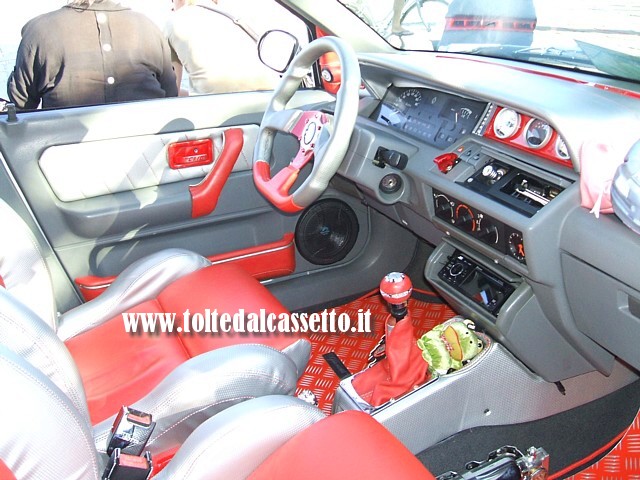 TUNING - Posto guida e interni grigio-rosso di una Renault Clio vecchio tipo