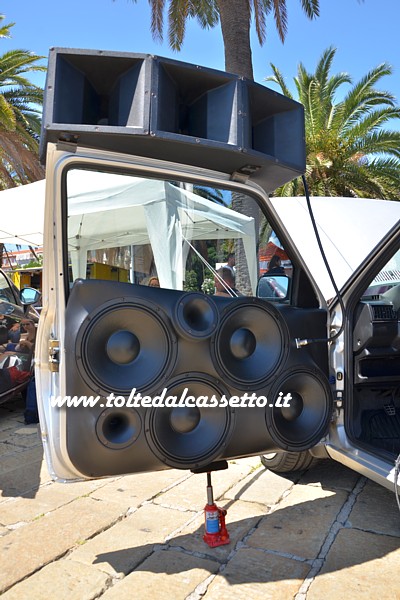 TUNING - Portiera da competizione audio di VOLKSWAGEN Golf GL con 6 altoparlanti 18 Sound pi 3 subwoofer supplementari. Visto l'elevato peso, la struttura deve essere sostenuta da un martinetto idraulico