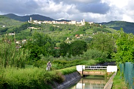 CASTELNUOVO MAGRA - Il Canale Lunense scorre nel fondovalle. Sullo sfondo, arroccato sulla collina, il centro storico del borgo