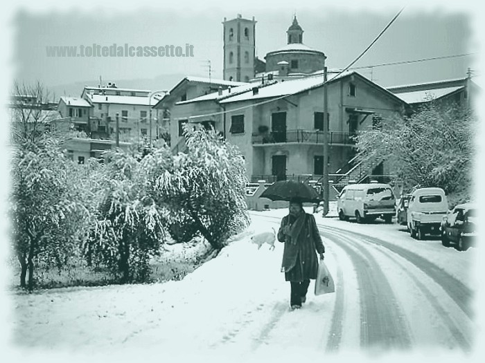 SANTO STEFANO DI MAGRA (Via Carso) - Scorcio sulla chiesa parrocchiale e passante che si ripara con un ombrello durante la nevicata di Gennaio 2006