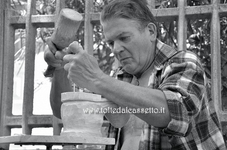 SAN PIETRO VARA in fiera - L'artista Gino Casagranda mentre scolpisce uno scarpone in legno