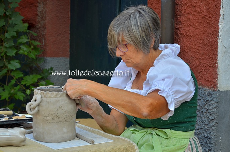 SAN PIETRO VARA in fiera - Un'artista che fa parte dell'Associazione Culturale Scultori di Bedollo ed Artisti di Strada (Arti e Antichi Mestieri) mentre modella un vaso di terracotta