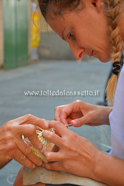 SAN PIETRO VARA in fiera - Due appartenenti all'Associazione Culturale Scultori di Bedollo ed Artisti di Strada (Arti e Antichi Mestieri) costruiscono un cestino in vimini