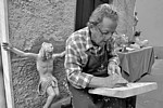 SAN PIETRO VARA in fiera - L'artista del legno Sergio Vettori al lavoro su un bassorilievo. Dietro di lui la scultura del Cristo in croce