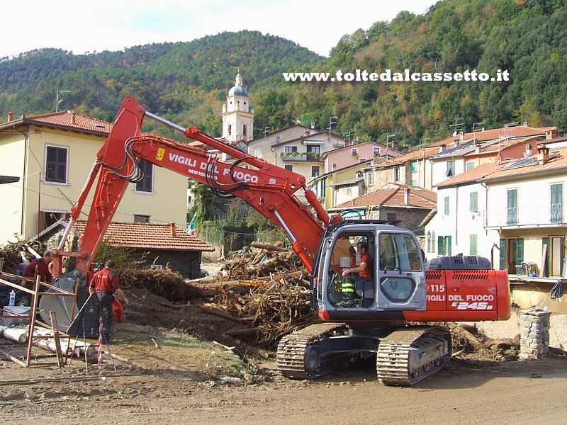 PIGNONE - Una ruspa dei Vigili del Fuoco al lavoro per rimuovere il legname che l'alluvione ha ammassato nei pressi del Ponte Vecchio causandone anche il crollo