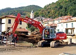 PIGNONE - Una ruspa dei Vigili del Fuoco intenta a liberare il greto del torrente dal legname accumulatosi durante il nubifragio del 25-10-2011