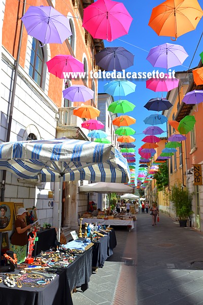 PIETRASANTA - Ombrelli variopinti sospesi su Via Mazzini