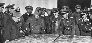 Sul fronte russo, il 25 e 26 agosto 1941, si tiene un vertice fra Hitler e Mussolini. Nella foto i due stanno esaminando una mappa dello stato bellico insieme ai comandanti militari