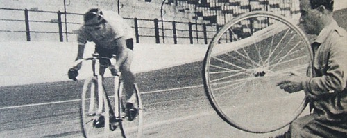 NOVEMBRE 1942 - Fausto Coppi sfreccia davanti a un meccanico che tiene in mano una ruota di scorta durante il record dell'ora al Vigorelli di Milano