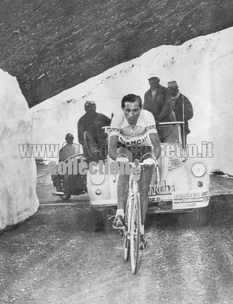 FAUSTO COPPI in fuga sullo Stelvio tra due mura di neve. Dietro di lui l'ammiraglia della Bianchi e un poliziotto motociclista