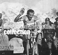 GIRO D'ITALIA 1953 - Fausto Coppi transita sul Passo dello Stelvio. Fresco e sorridente saluta i tifosi col braccio alzato